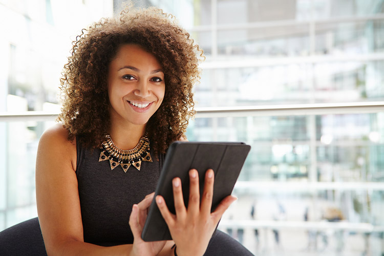 Young African American college student using a tablet computer at her first internship.