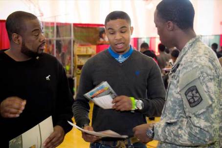 Black College Expo attendee talks with military recruiter at about college options after high school.