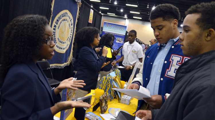 A representative at the Southern University and A&M College booth speaks with high schools students at the Atlanta Black College Expo.