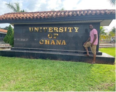 Dr. Karl Jackson posing in front of the University of Ghana sign during his Fulbright journey to Ghana.
