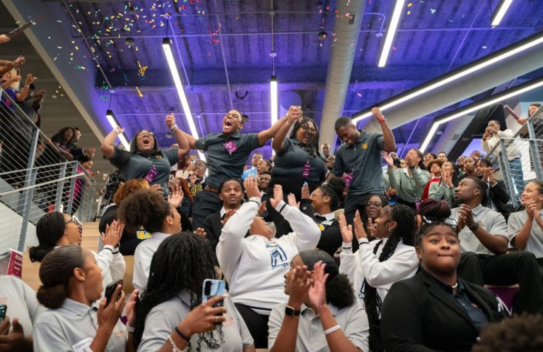 Excited students from North Carolina A&T State University, dressed in grey shirts, cheer enthusiastically as they celebrate their first-place victory at the 2023 Moguls In the Making competition.
