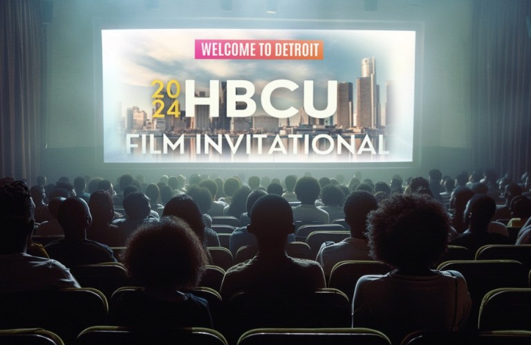 Audience watching the 2024 HBCU Film Invitational on a large screen in a theater with the Detroit skyline in the background.
