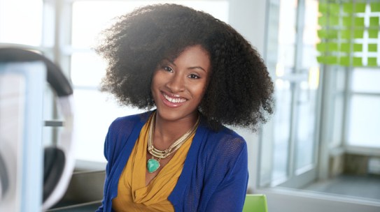 A friendly African American HBCU college student at her work study job on campus.